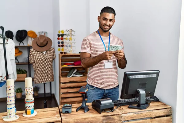 衣料品店で働くドルを持っている若いアラブ人男性 — ストック写真