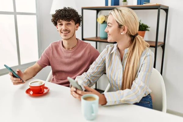 年轻夫妇在家里用智能手机喝咖啡 — 图库照片