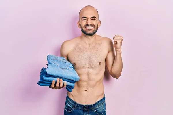 Junger Mann Mit Glatze Hält Stapel Gefalteter Jeans Und Schreit — Stockfoto