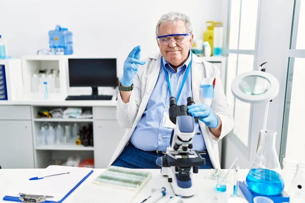 科学実験室で働く先輩の白人男性が希望と目を閉じて笑顔を交わした 幸運と迷信の概念は — ストック写真