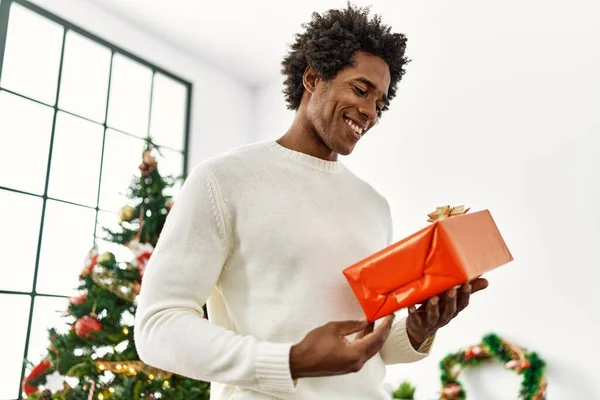 Joven Afroamericano Hombre Sosteniendo Regalo Pie Junto Árbol Navidad Casa — Foto de Stock