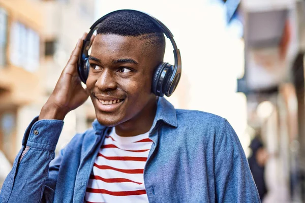 若いアフリカ系アメリカ人の男が市内のヘッドフォンを使用して幸せな笑顔 — ストック写真