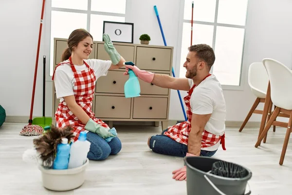 Joven Pareja Caucásica Limpiando Jugando Con Pulverizador Casa —  Fotos de Stock