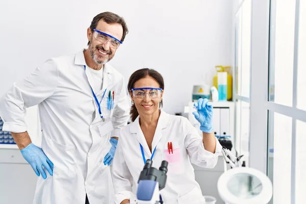 实验室里穿着科学家制服的中年男人和女人伴侣分析样本 — 图库照片