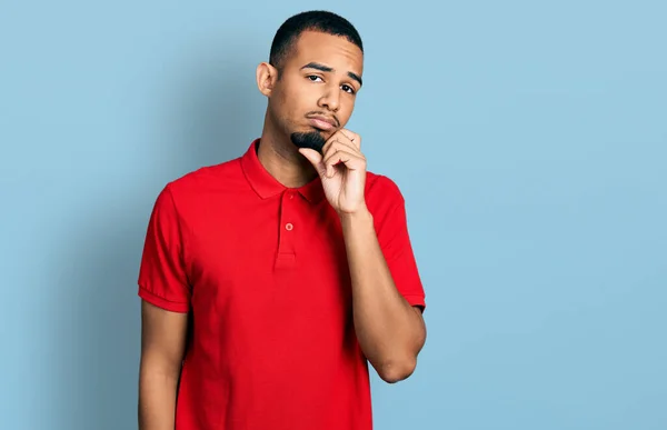 Hombre Afroamericano Joven Usando Polo Casual Pensando Concentrado Duda Con —  Fotos de Stock