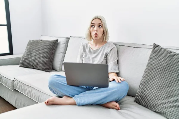 Young Caucasian Woman Using Laptop Home Sitting Sofa Making Fish — Stockfoto