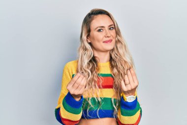 Renkli süveter giyen güzel sarışın kadın. Elleriyle para hareketi yapıyor. Maaş istiyor. 