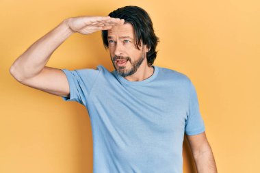 Orta yaşlı, günlük kıyafetler giyen, mutlu ve tebessüm eden bir beyaz adam. arama kavramı. 