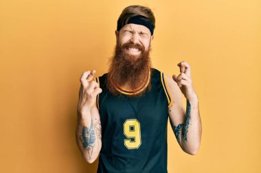 Uzun sakallı, basketbol forması giyen, umut ve gözlerin kapalı gülümseyerek el sallayan kızıl saçlı bir adam. Şans ve batıl inançlar. 