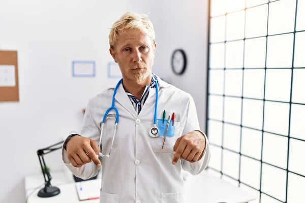 Young Blond Man Wearing Doctor Uniform Stethoscope Clinic Pointing Looking — 图库照片