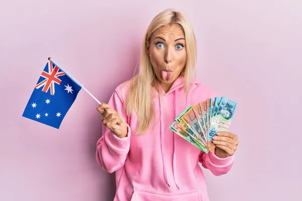 Νεαρή Ξανθιά Γυναίκα Αυστραλιανή Σημαία Και Δολάρια Βγάζει Γλώσσα Χαρούμενη — Φωτογραφία Αρχείου