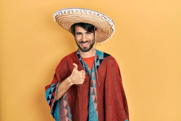 Homem Hispânico Jovem Segurando Chapéu Mexicano Fazendo Polegares Felizes Gesto — Fotografia de Stock