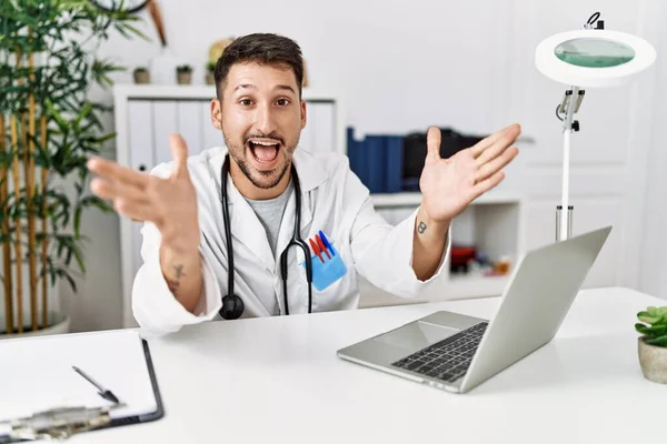 Young Doctor Working Clinic Using Computer Laptop Celebrating Crazy Amazed — Fotografia de Stock
