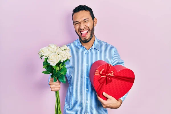 带着胡子的西班牙男人带着结婚周年礼物 一束鲜花带着滑稽的表情伸出舌头 高兴极了 — 图库照片