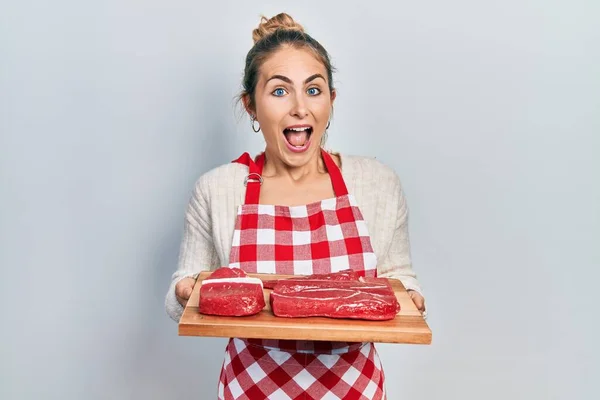 Young Caucasian Woman Holding Board Raw Meat Celebrating Crazy Amazed — Φωτογραφία Αρχείου