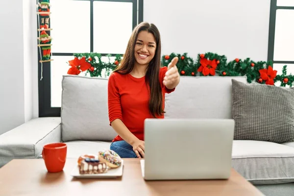 Jovem Morena Usando Laptop Sentado Sofá Natal Sorrindo Amigável Oferecendo — Fotografia de Stock