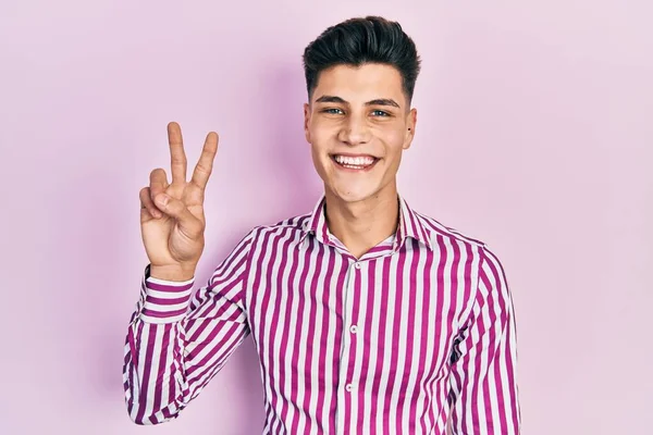 Молодий Іспаномовний Чоловік Повсякденному Одязі Посміхається Дивлячись Камеру Показуючи Пальці — стокове фото