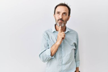 Orta yaşlı, sakallı, soyutlanmış arka planda duran İspanyol bir adam parmak çenesinde şüpheye yoğunlaşmıştı. 