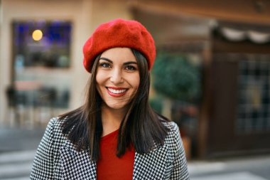 Genç İspanyol kadın gülümseyerek şehirde mutlu mesut dikiliyor..