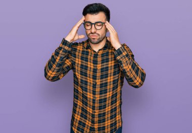 Sakallı, sıradan kıyafetler giyen, gözlüklü, baş ağrısı çeken çaresiz ve stresli İspanyol bir adam. Çünkü ağrı ve migren ağrısı var. Eller başının üstünde.. 