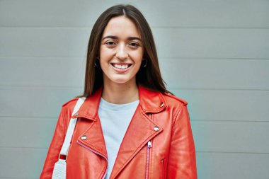 Genç İspanyol kadın gülümseyerek şehirde mutlu mesut dikiliyor..