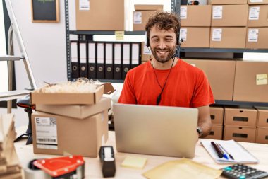 Depoda mutlu ve havalı bir gülümsemeyle çalışan genç bir İspanyol çağrı merkezi ajanı. şanslı kişi. 