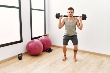 Spor merkezinde dambılları kullanan İspanyol bir genç.