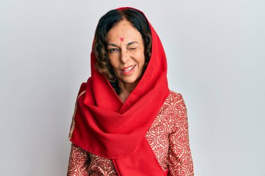 Orta yaşlı İspanyol kadın geleneksel Sherwani elbisesi giyiyor kameraya seksi bir ifadeyle bakıyor, neşeli ve mutlu bir yüzle.. 