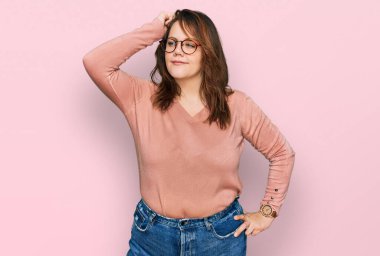 Gündelik kıyafet giyen ve gözlük takan genç ve cüsseli bir kadın soru sorup kafasını karıştırıyor. Şüpheyle kararsız, kafa kafaya düşünerek. Düşünceli kavram. 