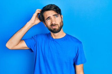 Gündelik kıyafetler giyen genç İspanyol adam soru sorup kafasını karıştırıyor. Şüpheyle kararsız, kafa kafaya düşünerek. Düşünceli kavram. 