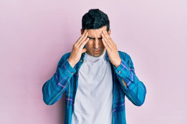 Yakışıklı, İspanyol bir adam, stresten dolayı başı ağrıyan günlük kıyafetler giyiyor. migren ağrısı. 