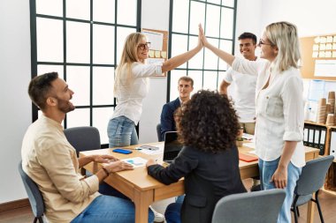 Ofiste buluşurken gülümseyen iki işçi beşlik çakıyor..