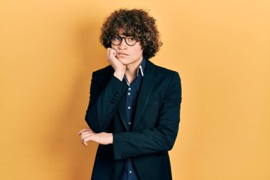 Handsome young man wearing business jacket and glasses thinking looking tired and bored with depression problems with crossed arms. 