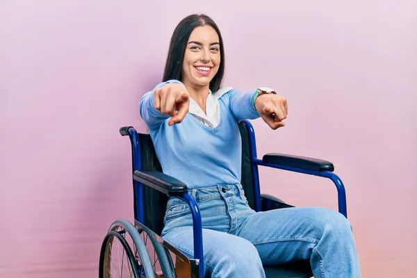 車椅子に座っている青い目の美しい女性と指でカメラを指差し ポジティブで陽気な笑顔 — ストック写真