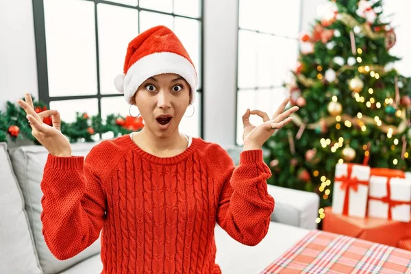 Mladá Hispánka Krátkými Vlasy Vánočním Kloboukem Sedící Pohovce Vypadala Překvapeně — Stock fotografie