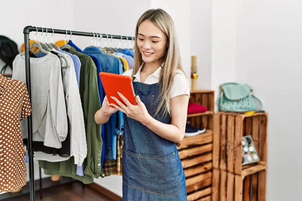 中国年轻女子在服装店工作时使用触摸板 — 图库照片