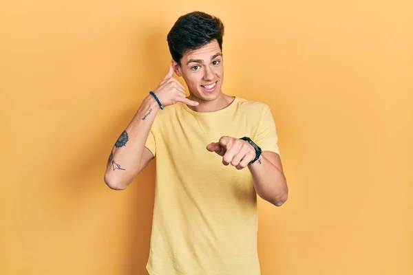 Jovem Hispânico Vestindo Camiseta Amarela Casual Sorrindo Conversando Gesto Telefônico — Fotografia de Stock
