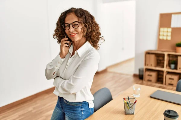 Mujer Hispana Mediana Edad Sonriendo Confiada Hablando Teléfono Inteligente Oficina —  Fotos de Stock