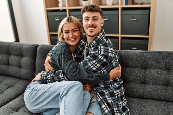 Jovem Casal Caucasiano Sorrindo Feliz Abraçando Sentado Sofá Casa — Fotografia de Stock