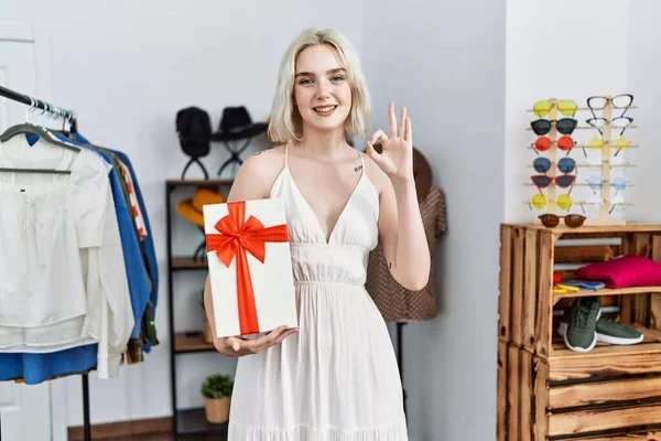 Young Caucasian Woman Holding Gift Retail Shop Doing Sign Fingers — Stock fotografie