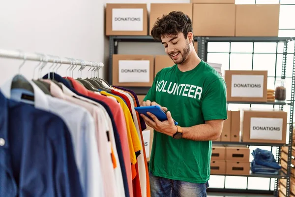 Yardım merkezinde dokunmatik ped kullanan gönüllü üniformalı bir İspanyol genç.