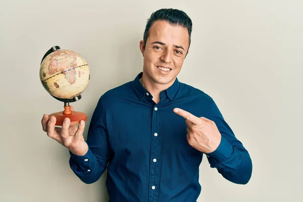 Handsome Young Man Holding Small World Ball Smiling Happy Pointing — Photo
