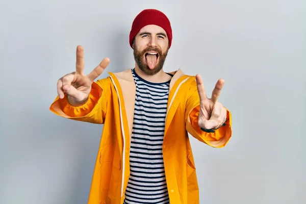 Hombre Caucásico Con Barba Vistiendo Impermeable Amarillo Sonriendo Con Lengua —  Fotos de Stock
