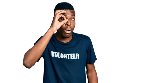 ボランティアのTシャツを着た若いアフリカ系アメリカ人の男性は 驚くべき顔 目を指で見てショックを受けました 信じられない表現 — ストック写真