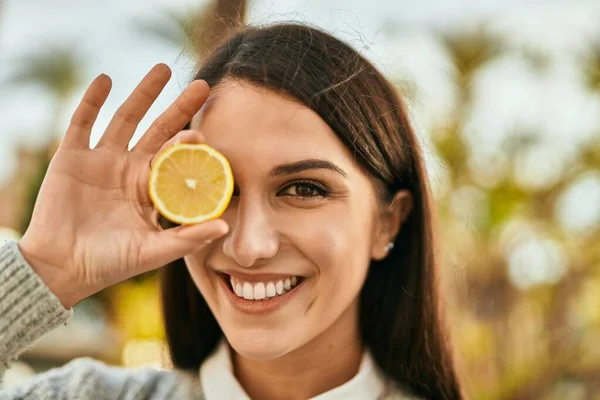 Молодая Латиноамериканка Улыбается Счастливая Держа Кусочек Лимона Над Глазом Города — стоковое фото