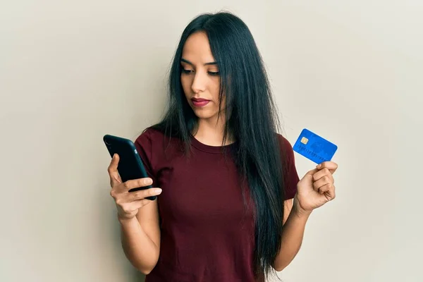 Ung Latinamerikansk Flicka Håller Smartphone Och Kreditkort Avslappnad Med Allvarliga — Stockfoto