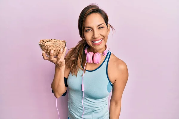 Young Latin Woman Wearing Gym Clothes Using Headphones Holding Cornflakes — Stock Photo, Image