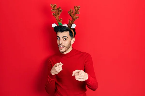 Fiatal Spanyol Férfi Aranyos Karácsonyi Rénszarvas Szarvakat Visel Ujjal Mutogat — Stock Fotó
