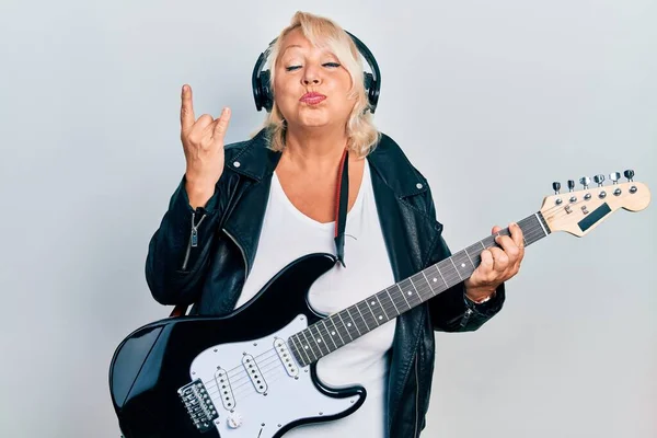 Orta Yaşlı Sarışın Elektro Gitar Çalan Parmaklarıyla Boynuz Işareti Yapan — Stok fotoğraf