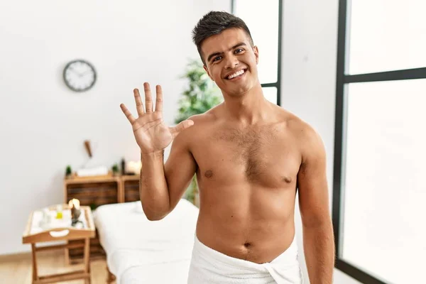 Young Hispanic Man Standing Shirtless Spa Center Showing Pointing Fingers — Stock fotografie
